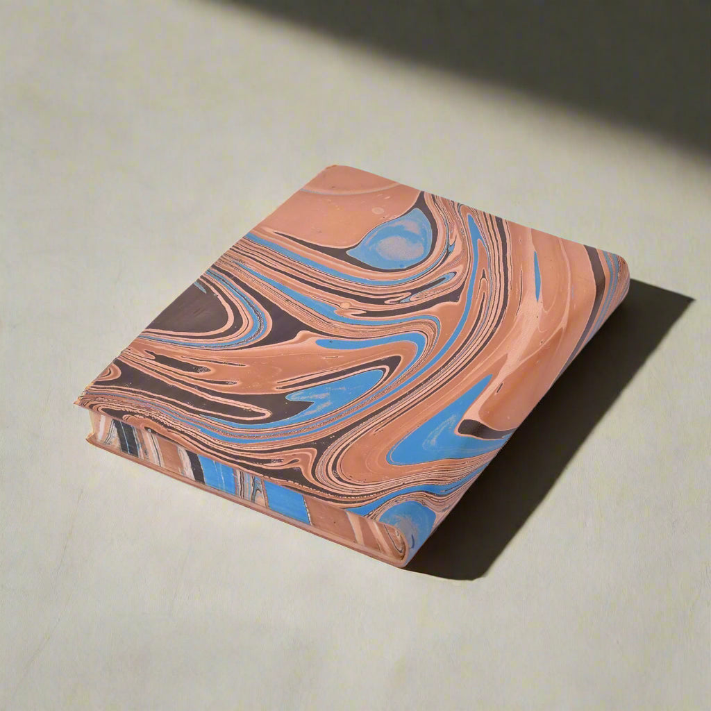 Marbled notebook with brown, blue, and black pattern on a white background