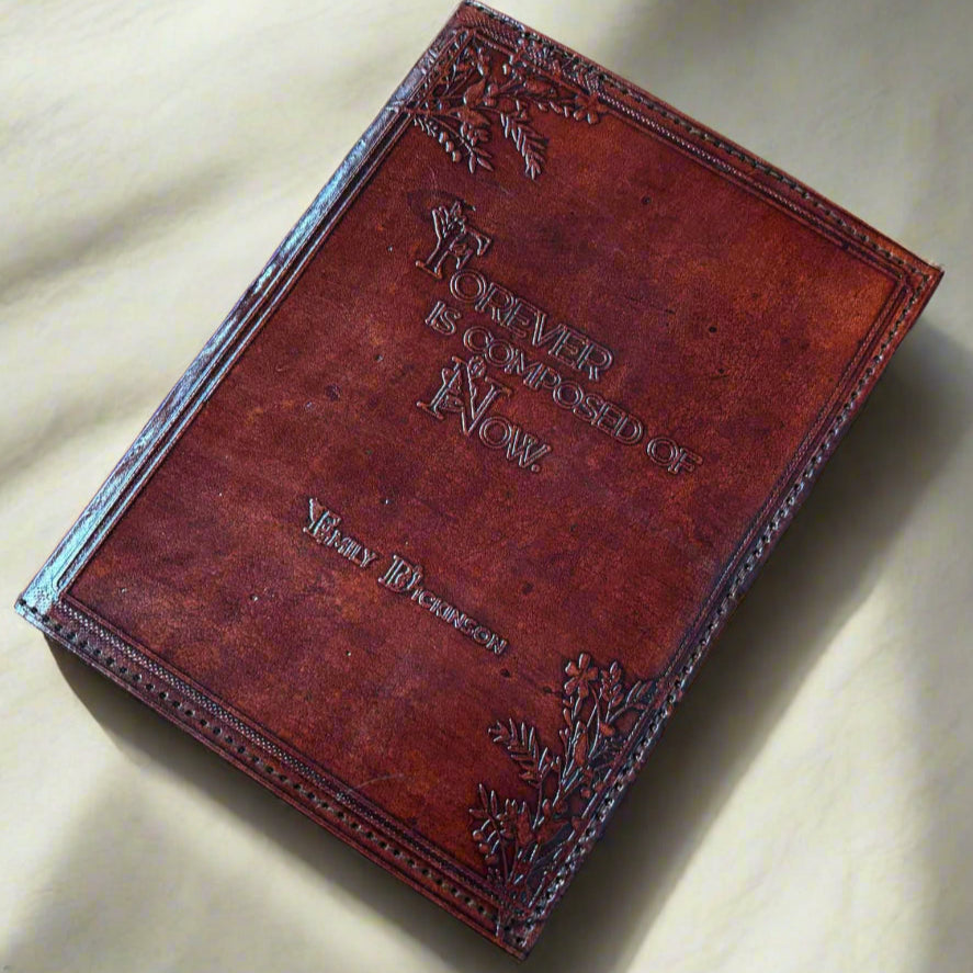 Brown leather-bound book with embossed text on a brown surface