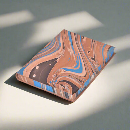 Marbled notebook with brown, blue, and beige colors on a white background