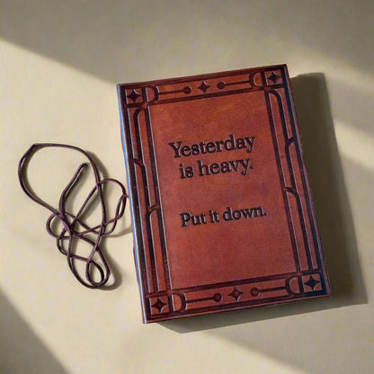 Brown leather-bound book with embossed text on a beige background