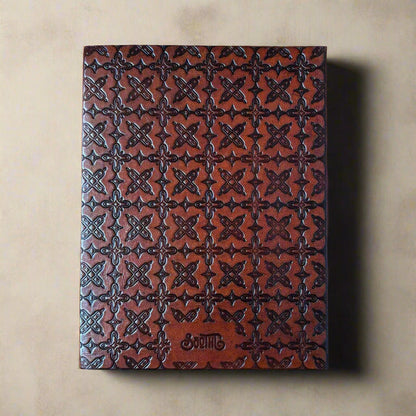 Brown leather notebook with embossed pattern on a beige background