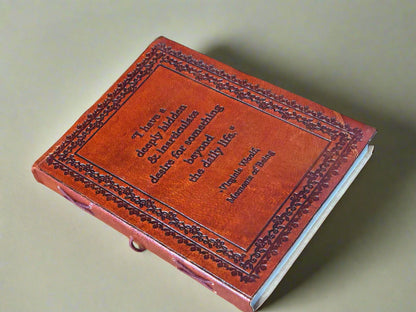 Brown leather-bound book with embossed text on a beige background