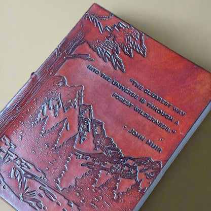 Brown leather-bound book with embossed design and quote on a brown background