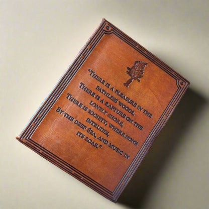 Brown leather-bound book with engraved text and design on a matching brown background