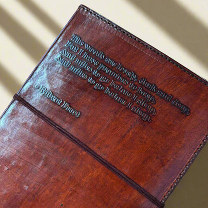 Brown leather-bound book with embossed text on a beige background