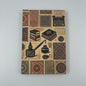 Close-up of the Grand Trunk Notebook cover showing ink pots and literary symbols