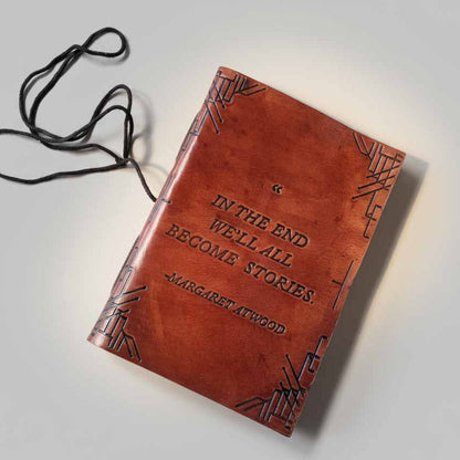 Brown leather notebook with embossed text on a light gray background