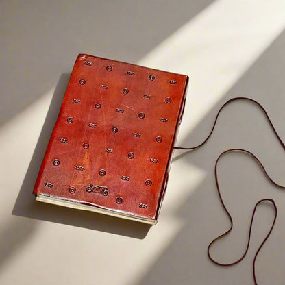 A handcrafted red leather journal with an embossed inspirational quote - dedicated space to process your thoughts, cultivate positivity, and reinforce